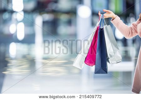 Beautiful Happy Girl With Credit Card And Shopping Bags In Shopping Mall. Shopping Center In The Bac