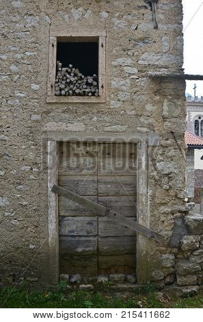 An old wooden door in a derelict building the historic hill village of Erto in Friuli Venezia Giulia north east Italy