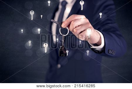 Businessman in suit holding keys with keys graphics around and dark background