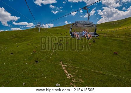 GODERZI SKI RESORT, GEORGIA - 08 AUGUST 2017: happy tourists waving hands in cableway carriage over mountain landscape of Adjara region