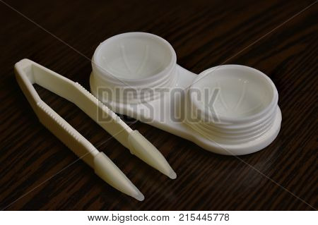 tweezers storage container lenses on the table