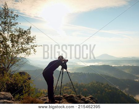 Photographer  On Cliff. Nature Photographer Takes Photos With Mirror Camera On Peak Of Rock.