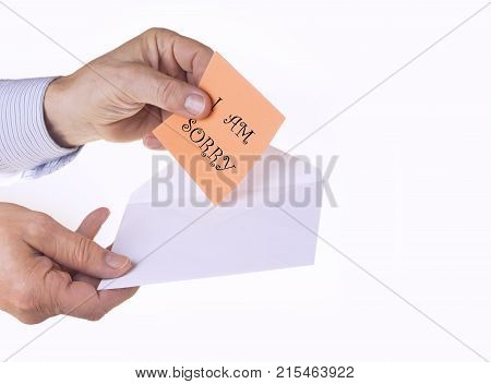 White envelope with paper note with man hand on the white background. I am sorry concept.