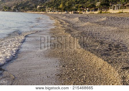 View of the breaking beach and coastal walk in Lourdata at sunset on the island of Kefalonia