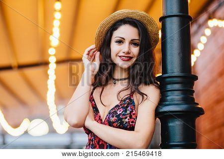 Carefree Slim Woman With Dark Luxurious Hair, Shinig Eyes And Red Rouged Lips, Dressed In Straw Hat