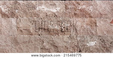 Stone wall texture, travertine tiles facing stone background