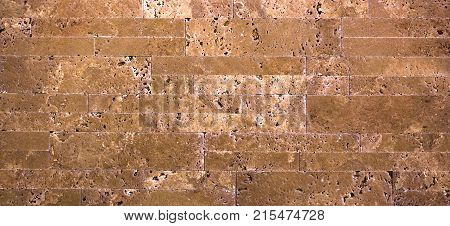 Stone wall texture, travertine tiles facing stone background