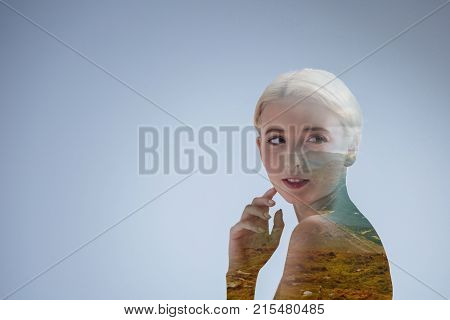 Recalling my past. Pensive young woman turning her head and touching her cheek while thinking about something joyful.