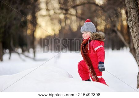 Little Boy In Red Winter Clothes Having Fun With Fresh Snow