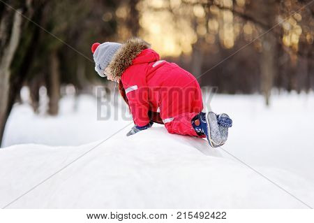 Little Boy In Red Winter Clothes Having Fun With Fresh Snow
