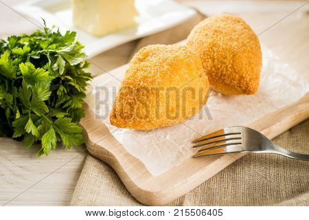 Chicken Kiev cutlets with parsley leaves and butter.