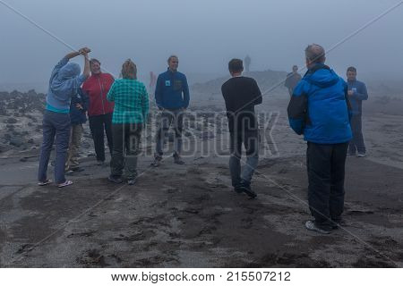 Kamchatka Peninsula, Russia - August 26, 2016: Group of tourists in the fog of the volcano caldera Gorely. Kamchatka Peninsula.