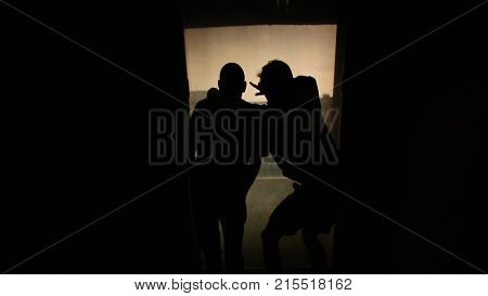 Silhouette of two other men looking out the window. Footage. Two friends in front of the window, the concept of friendship.