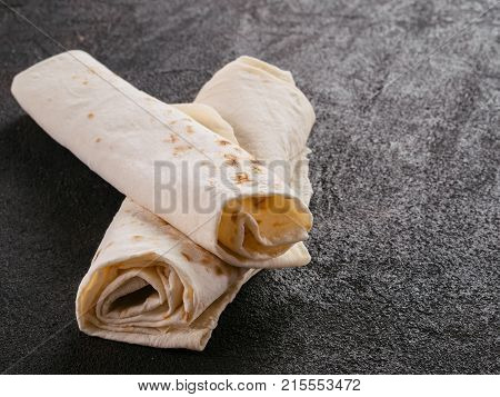 Armenian flat bread lavash. Pita bread on black cement background. Copy space.
