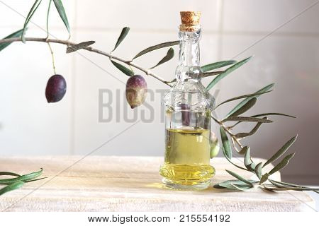 Still Life With Olive Branch And Olive Oil In A Bottle On A Wooden Cutting Board.