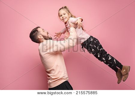 The surprised and cheerful father playing with daughter at pink studio