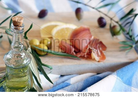 Bottle With Olive Oil On A Breakfast Background With Olives And Bacon In The Morning
