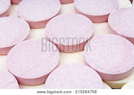 Stack of vitamin mineral supplement effervescent tablets pattern texture. Multivitamin supplement tablet. Soluble Vitamin. Fizzy tablet. Orange flavored effervescent tablets. Closeup.