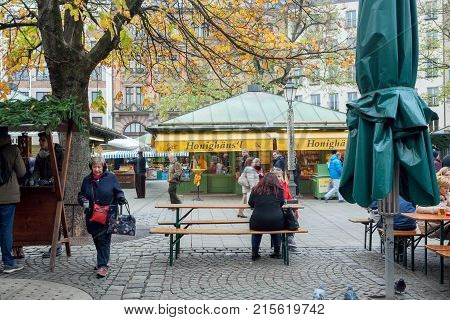 MUNICH, GERMANY - NOVEMBER 16, 2017: Women sitting at table of outdoor cafe at famous Viktualienmarkt on November 16, 2017. Bavaria is famous for its breweries and the Weissbier -wheat beer