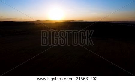 Beautiful aerial view from drone Sugar cane field with sunset sky nature landscape background. Majestic sunset in the nature landscape. Aerial panorama of blue calm river in the forest and fields at the sunset. Summer nature landscape. Aerial survey of wh