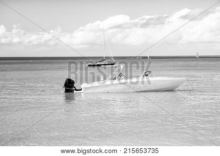 traveling and vacation sport and sailing man yachtsman on motorboat yacht on sea ocean water coast sunny summer outdoor on blue cloudy sky background in St. John Antigua