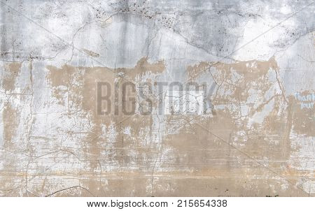 Distressed concrete and stucco wall with cracks and peeling paint a vintage look.