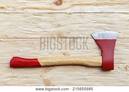 Red ax on a wooden background top view with space for text
