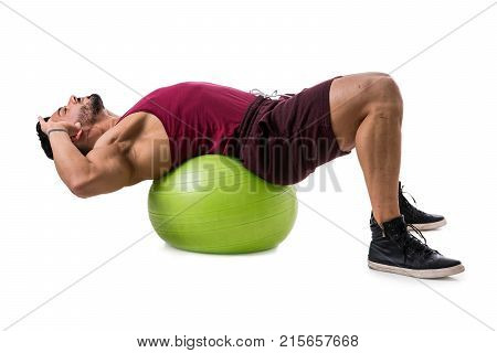 Attractive bodybuiler man exercising abs on an exercise ball in studio shot, isolatedo on white