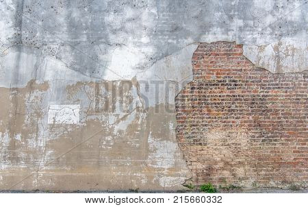 Distressed brick and stucco wall with cracks and peeling paint a vintage look.