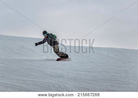 Snowboarder In A Black Helmet Riding On A Snowy Track.