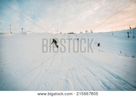 Snowboarder In A Black Helmet Riding On A Snowy Track.