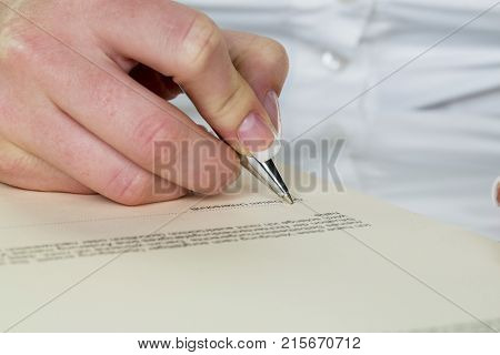 hand with fountain pen signs contract
