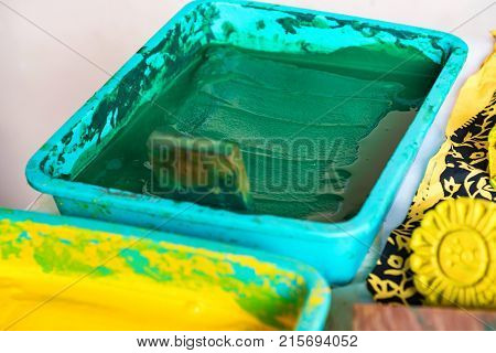 Close up stamps and bright yellow and green dye for cloth