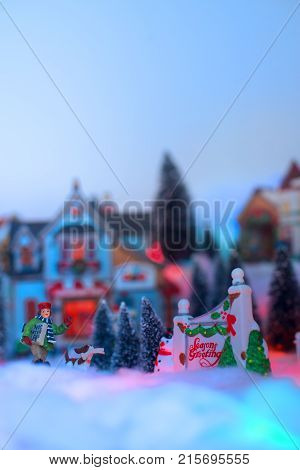 Kid deliver holiday message walks next season greeting sign with the background is a snow Christmas town