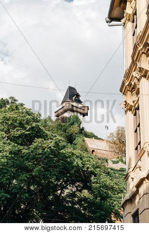 Graz, Austria - August 11, 2017: Low angle view of old buildings in historical city center of Graz with Uhrturm on background
