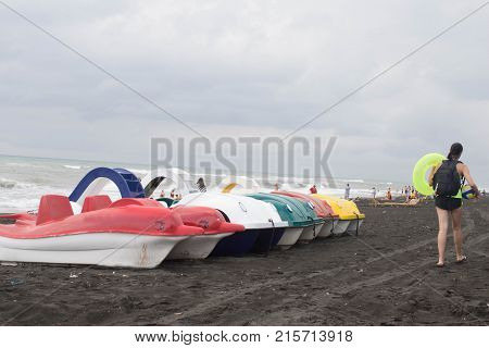 pedal boat on a sandy beach and for hire at the seaside. Girl on the beach. Travel or sea vacations concept