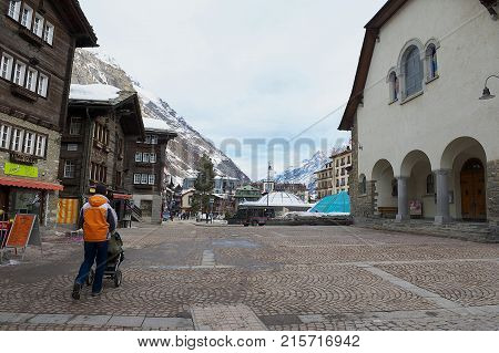 ZERMATT, SWITZERLAND - MARCH 04, 2009: View to the square and traditional wooden buildings in Zermatt, Switzerland. Zermatt is one of the most popular ski resorts in Switzerland.