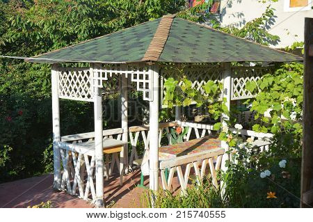 Wooden alcove arbor pavilion bower summer house garden house in the garden.