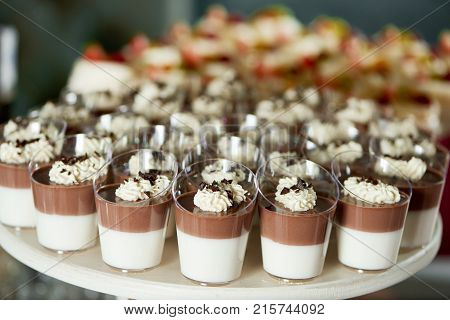 Horizontal shot of delicious chocolate flavored jellies served at the restaurant candy buffet decorated with whippe cream and chocolate crust copyspace layout background concept.