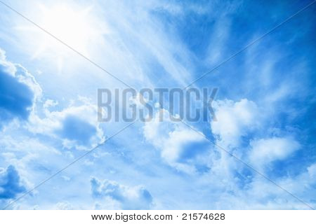 blauer Himmel mit Wolken und Sonne.
