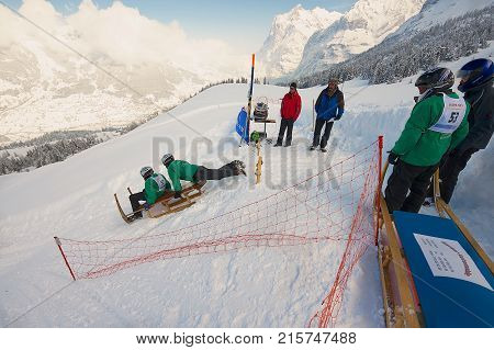 GRINDELWALD, SWITZERLAND - MARCH 07, 2009: Unidentified men ride traditional horn-sledge at 12-th annual Horn-Sledge Race from Alpiglen to Grund in Grindelwald, Switzerland.