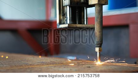Oxygen torch cuts steel sheet. CNC gas cutting machine. Bright sparks of melting metal