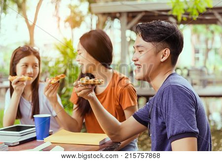 Students asian group together eating pizza in breaking time early next study class having fun and enjoy party italian food slice with cheese delicious at university outdoor