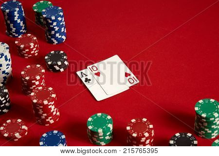 Poker cards and gambling chips on red background. Top view. Copy space. Still life. Flat lay. Cards - Ace and Ten