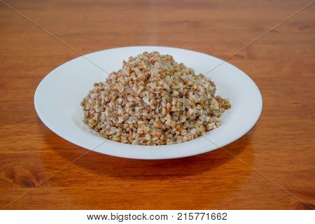 Buckwheat porridge in white plate. Healthy food.