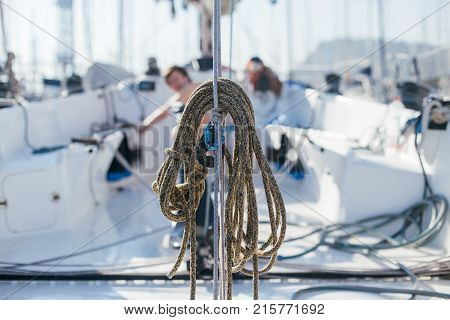 Nautical ropes buntine capstan and cablet piled up on deck of professional racing yacht or sailboat attached to mast or forestay different colors expensive sailing hobby
