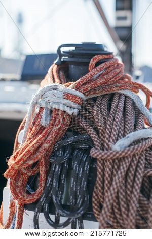 Nautical ropes buntine capstan and cablet piled up on deck of professional racing yacht or sailboat attached to mast or forestay different colors expensive sailing hobby