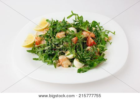 Salad with arugula and shrimp. Fresh dish with arugula, cherry tomatoes, shrimp on a plate.