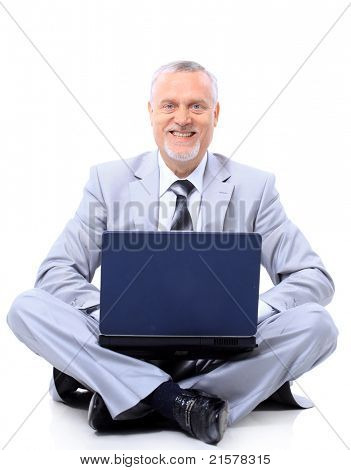Výkonný sedí na podlaze zkříženýma nohama s notebookem