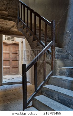 Ascending staircase with wooden balustrade and wooden closed ornate door at the background Prince Taz palace old Cairo Egypt